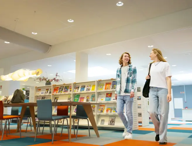 Twee studenten lopen door studiecentrum m en v
